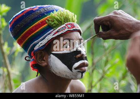 Western Highlanders preparing for a Sing-sing at the Paiya Show, applying face paint, Western Highlands near Mount Hagen, Papua New Guinea, August 2011 Stock Photo