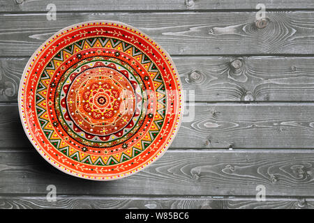 Set of decorative ceramic plates hand painted dot pattern with acrylic paints on a gray wooden background. Copy space Stock Photo