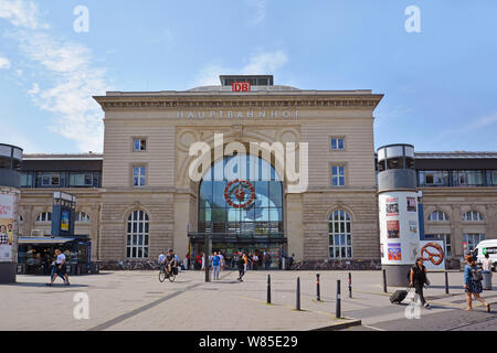 Front view of facade of Mannheim central railway station in old historical building with travelers passing by on summer day Stock Photo