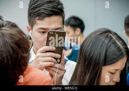 --FILE--A customer tries out an iPhone 7 smartphone at an Apple Store in Guangzhou city, south China's Guangdong province, 16 September 2016.   A comp Stock Photo