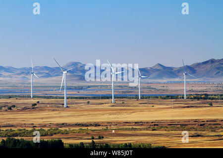 --FILE--Wind turbines whirl to generate electricity at a wind farm in Ulanhot city, north China's Inner Mongolia Autonomous Region, 13 October 2012. Stock Photo