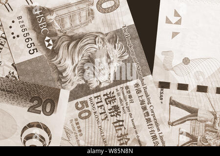 Different Hong Kong dollars bills on a dark background close up. Money background brown color toned Stock Photo