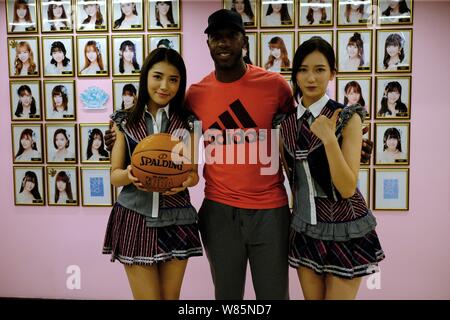 Retired NBA star Chauncey Billups, center, poses with Dai Meng, left, and Wu Zhehan, right, of Chinese girl group SNH48 at their concert in Shanghai, Stock Photo