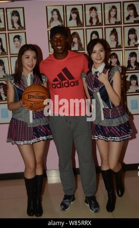 Retired NBA star Chauncey Billups, center, poses with Dai Meng, left, and Wu Zhehan, right, of Chinese girl group SNH48 at their concert in Shanghai, Stock Photo