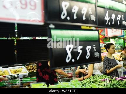 --FILE--Chinese customers shop for vegetables at a supermarket in Hangzhou city, east China's Zhejiang province, 9 August 2016.   China is confident o Stock Photo