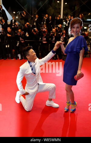 --FILE--Chinese actor Wang Baoqiang, left, kneels down in front of his wife Ma Rong as they arrive on the red carpet for a premiere event of his movie Stock Photo