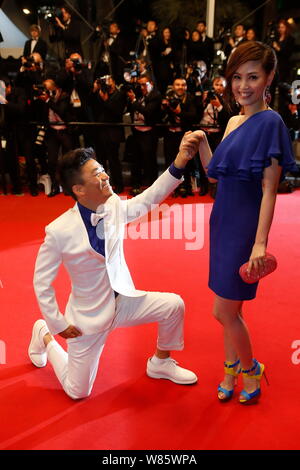 --FILE--Chinese actor Wang Baoqiang, left, kneels down in front of his wife Ma Rong as they arrive on the red carpet for a premiere event of his movie Stock Photo