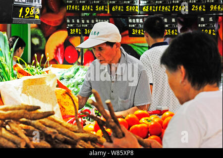 --FILE--Chinese customers shop for vegetables at a supermarket in Nanjing city, east China's Jiangsu province, 9 August 2016.   China is confident of Stock Photo