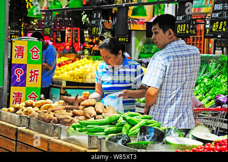 --FILE--Chinese customers shop for vegetables at a supermarket in Nanjing city, east China's Jiangsu province, 9 August 2016.   China is confident of Stock Photo