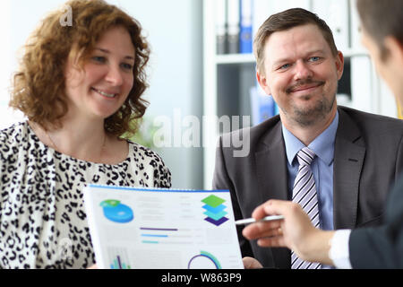 Portrait of bearded man and businesswoman in trendy outfit discussing important project and presenting charts and graphs to partner. Business meeting Stock Photo