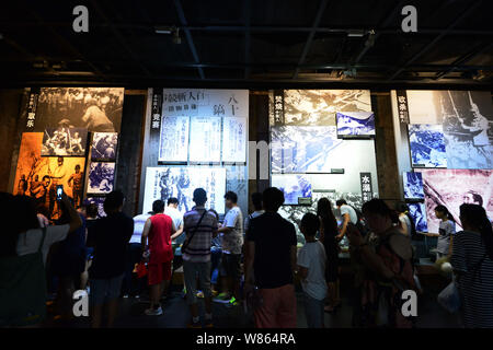 Visitors look at photos of Japanese soldiers killing Chinese people during World War II at the Memorial Hall of the Victims in Nanjing Massacre by Jap Stock Photo