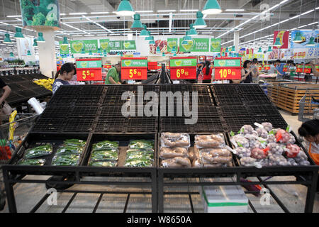 Chinese shoppers walk past nearly empty vegetable shelves at a supermarket before the coming of Typhoon Nida in Shenzhen city, south China's Guangdong Stock Photo
