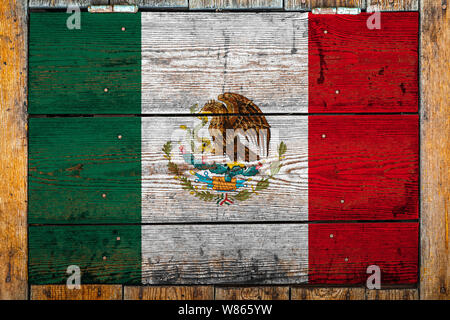 National flag of Mexico on a wooden wall background.The concept of national pride and symbol of the country.Flag painted on a wooden fence with metal Stock Photo