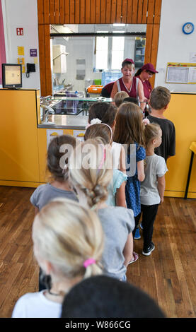 07 August 2019, Berlin: Before lunch, pupils stand in the cafeteria in the primary school on the Wuhlheide in the queue in front of the food counter. Photo: Jens Kalaene/dpa-Zentralbild/ZB