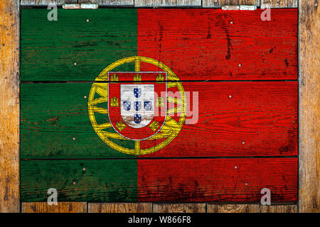 National flag of Portugal on a wooden wall background.The concept of national pride and symbol of the country.Flag painted on a wooden fence with meta Stock Photo