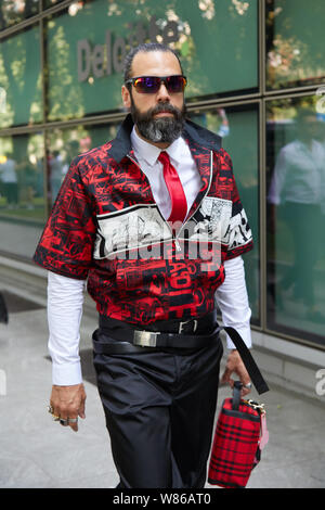MILAN - JUNE 15: Man with black Prada pouch and beige trousers before  Alberta Ferretti fashion show, Milan Fashion Week street style on June 15,  2018 Stock Photo - Alamy
