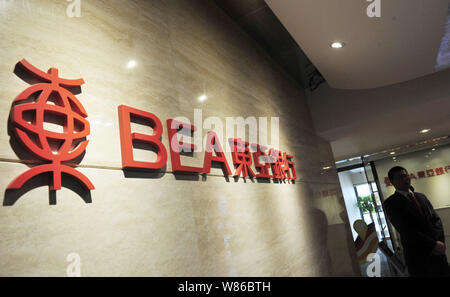 --FILE--An employee poses at a branch of BEA (The Bank of East Asia) in Fuzhou city, southeast China's Fujian province, 14 October 2014.  The Bank of Stock Photo