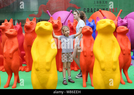 A young girl poses for photos with plastic mongooses and other animals made from recyclable plastic at an art installation exhibition by the Cracking Stock Photo