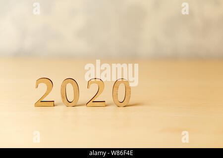 2020 Happy New Year, design concept. 2020 made from wooden letters, standing on a light bright wooden background Stock Photo