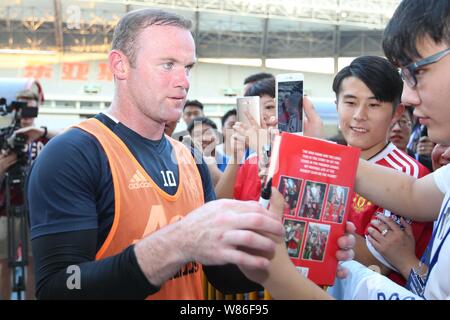 Wayne Rooney of Manchester United signs autographs for fans during a training session for the Shanghai match of the 2016 International Champions Cup C Stock Photo