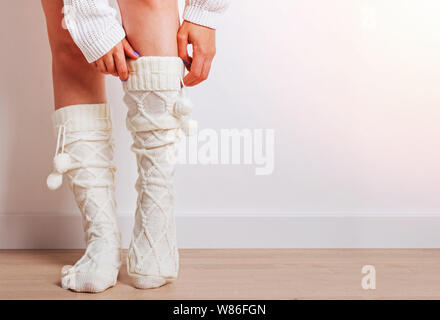 Woman with her feet close up wearing warm knitted socks in home. Winter or autumn concept Stock Photo