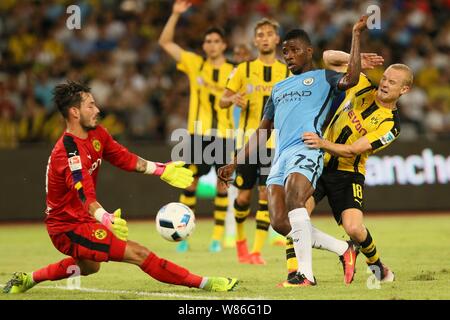 Kelechi Iheanacho of Manchester City, center, challenges Sebastian Rode, right, and goalkeeper Roman Burki of Borussia Dortmund during the Shenzhen ma Stock Photo