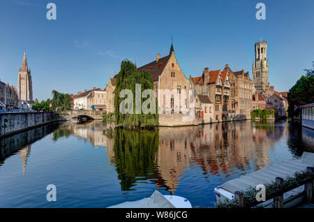 Bruges, Flanders, Belgium: reflection of facades of traditional Flemish buildings in the canal, with the belfry in the background. The historical cent Stock Photo