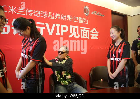 Italian football star Franco Baresi, left, signs his autograph on an AC Milan jersey of a Chinese fan during a meet and greet at a branch of Bank of Q Stock Photo