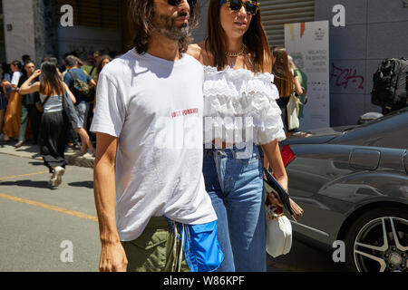 MILAN, ITALY - JUNE 16, 2019: Man and woman with white shirt and sunglasses before Etro fashion show, Milan Fashion Week street style Stock Photo