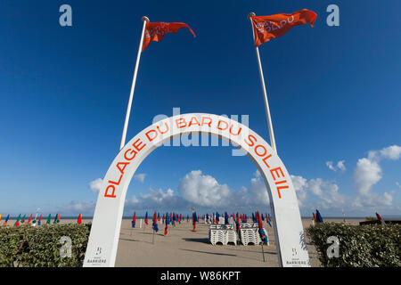 Cote Fleurie, part of the Normandy coast: folded parasols on the beach “plage du bar du soleil” in Deauville (north-western France). Stock Photo