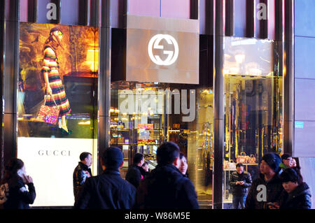 --FILE--Pedestrians walk past a fashion boutique of Gucci in Chongqing, China, 18 February 2016.   Both the Chinese mainland and Hong Kong continue to Stock Photo