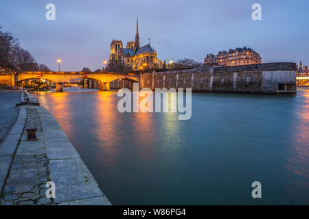 Paris (France): Notre-Dame Cathedral, in the 4th arrondissement (district) at nightfall. On the left, the “Pont de l'Archeveche” (Archbishop's Bridge) Stock Photo