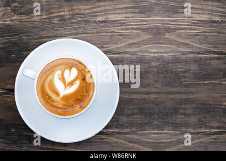 Fresh cappuchino or flat white coffee in a white cup with latte art on it, top view Stock Photo