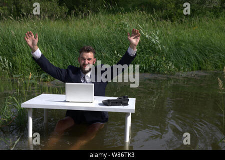 A bearded man in office clothes raised his hands up, makes a gesture for surrender. As if asking to save him, pull him out of the swamp. Office routin Stock Photo