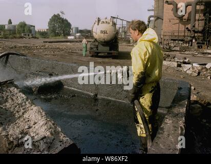 01 January 1992, Berlin, Lauchhammer: Federal States / Brandenburg / GDR / Industry 1992 End of the GDR. The large coking plant Lauchhammer is torn down. That's where they made coke out of brown coal. The photo symbolizes the dismantling of the GDR economy, environmental damage is being repaired, tar residues and all conceivable olefine pollutants must be removed. // Treuhand / Demolition / Economy / Environment During the Cold War, the GDR could not get coke for its steelworks from the West. She had to make it from lignite. The coking plant was supplied by 7 open pit lignite mines. After the Stock Photo