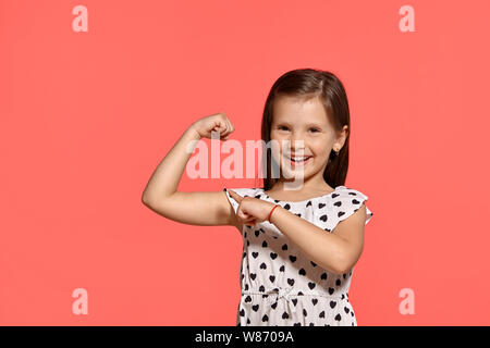 Close-up studio shot of beautiful brunette little girl posing against a pink background. Stock Photo