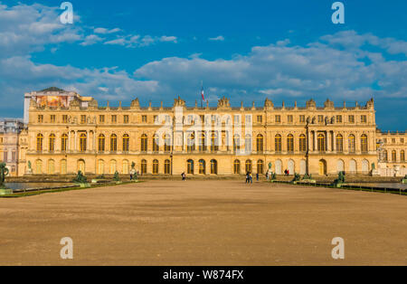 Perfect sunset panoramic view of the west facade of Versailles palace from the Water Parterre with two rectangular pools and a gravel path in the... Stock Photo