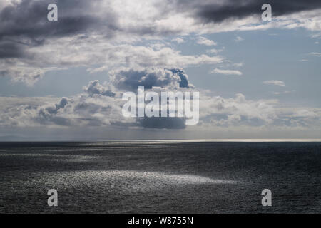 The view from Southerndown across the Bristol Channel with beautiful cloud formations and silver reflections on the sea, south Wales Coast. Stock Photo