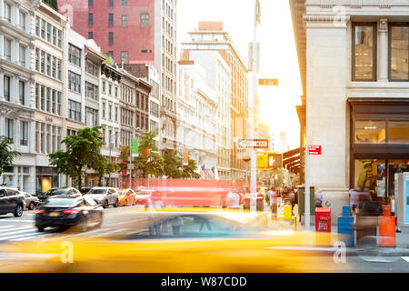 New York City street scene with yellow taxi cab driving down 5th Avenue through Midtown Manhattan NYC Stock Photo