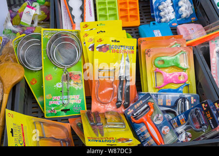 Kitchen utensils in colourful packaging for sale in the Saturday market in Honfleur, Normandy, France Stock Photo