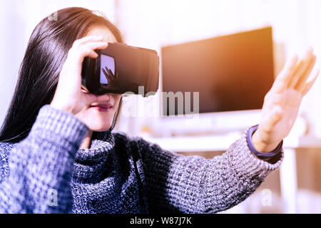 woman wearing virtual reality glasses. Smartphone using with VR headset Stock Photo