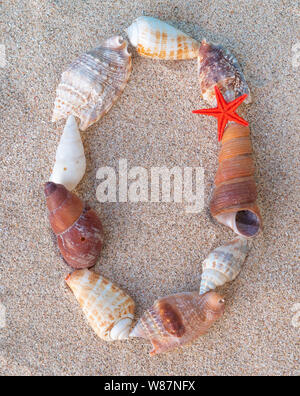 Calendar on sand. Year 2020. Seashells forming 0 inscription on yellow sand, new year concept Stock Photo