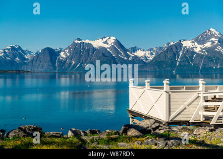 Picnic site rest stop area wooden table decoration and norwegian flag on lake fjord shore. Holidays relaxation on trip. Scandinavia Europe. Stock Photo