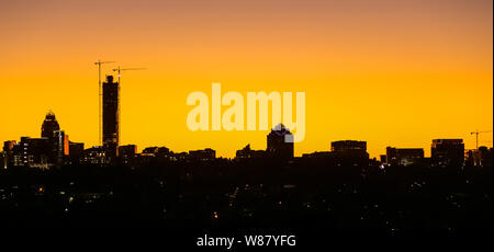 Johannesburg, South Africa - November 22 2018: Sunset Silhouette Skyline looking over construction cranes and buildings in Sandton CBD Johannesburg Stock Photo