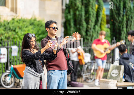 Cambridge, UK, August 1, 2019. Turists walking down and taking pictures at the street of Cambridge on a busy sunny day in front of Kings College Stock Photo