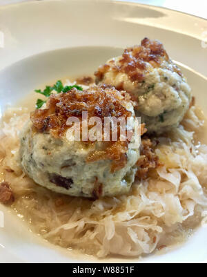 alpine dumlings with sauerkraut on a white plate with a blurred background Stock Photo