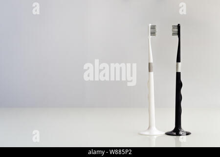 couple of black and white toothbrush on gray background, love and clean Stock Photo
