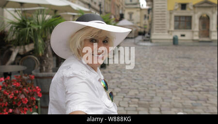 Senior female tourist pulling her friend through city street. Happy woman makes someone to follow her to the city Lviv, Ukraine. Vacation concept Stock Photo