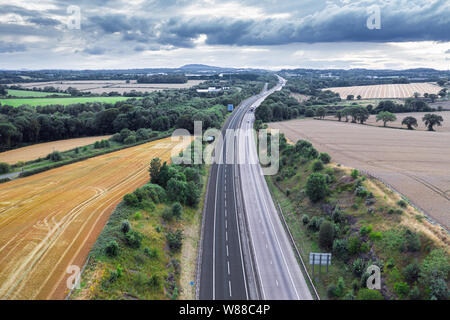 Drone shoot over dual lane motorway M54 across countryside fields at summer. Shropshire in United Kingdom Stock Photo