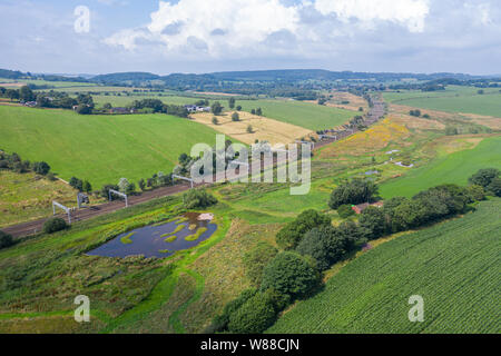 Aerial view over rail tracks across scenic countryside at bright sunny day. Whitmore in Staffordshire, UK Stock Photo